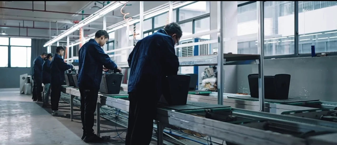 Technicians building speaker cabinets at the LA SOUNDX factory